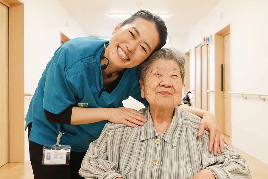 ナーシングシアラスの廊下で微笑む利用者様と介護士