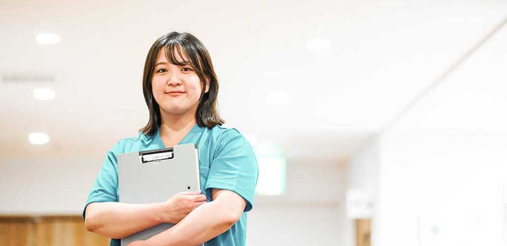 施設の廊下に立つ女性介護士