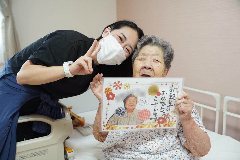 スタッフからメッセージカードをもらって笑顔の利用者さま