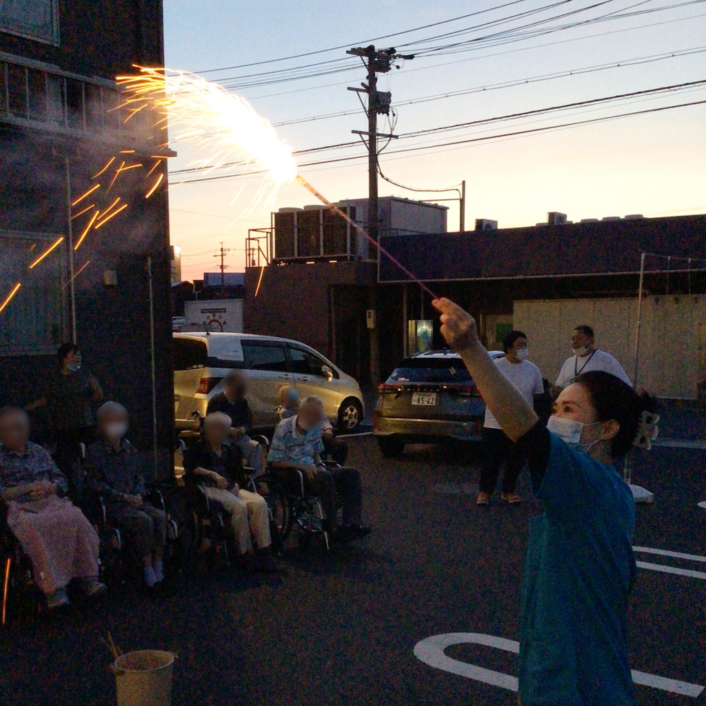 利用者さまたちの前で手筒花火を上げるスタッフ