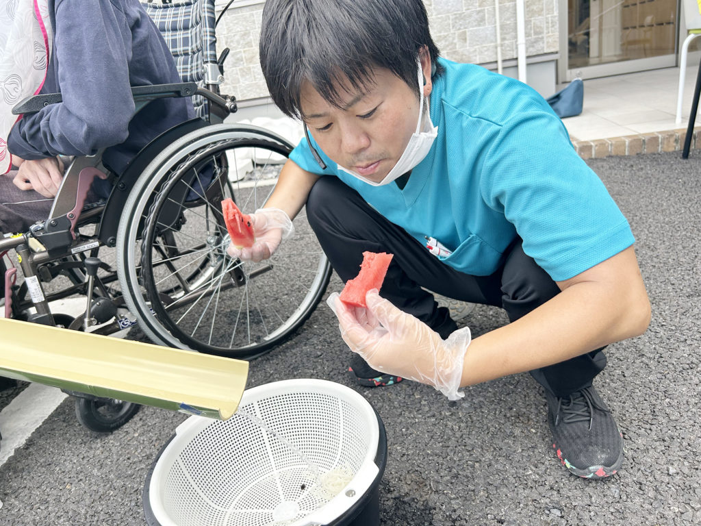 ご家族さまからいただいたスイカを食べるスタッフ