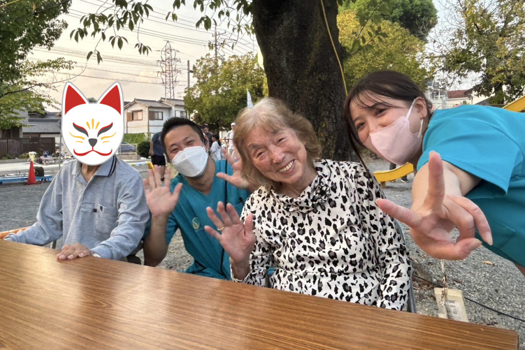 笑顔で机の前に並んで座る利用者さまたちとスタッフたち