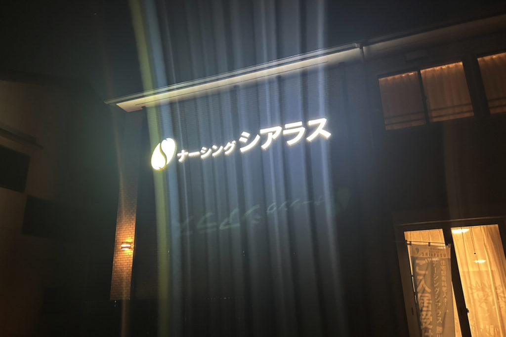夜の闇の中で光るナーシングシアラスの看板