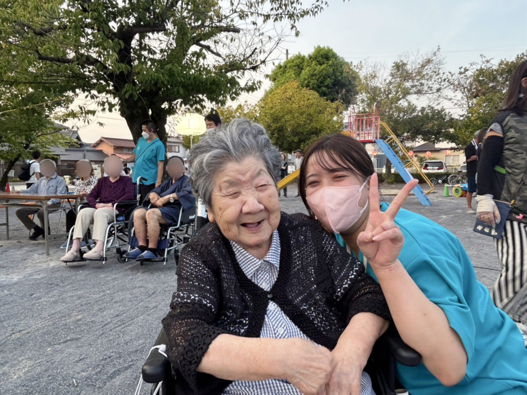 笑顔の利用者さまとピースするスタッフ