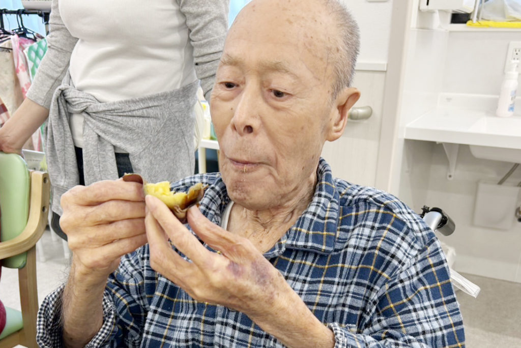 皮を剥いて焼き芋を食べる入居者さま