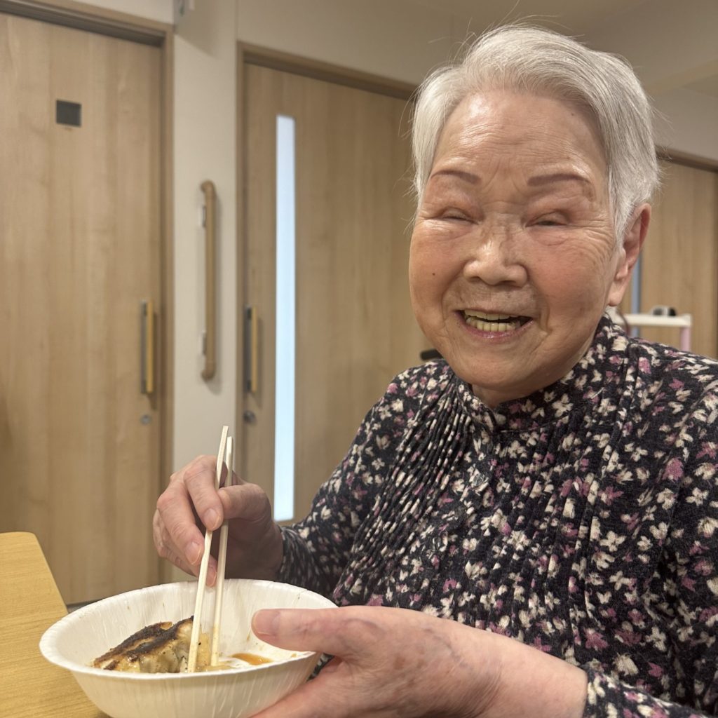 作った餃子を食べて笑顔の入居者さま