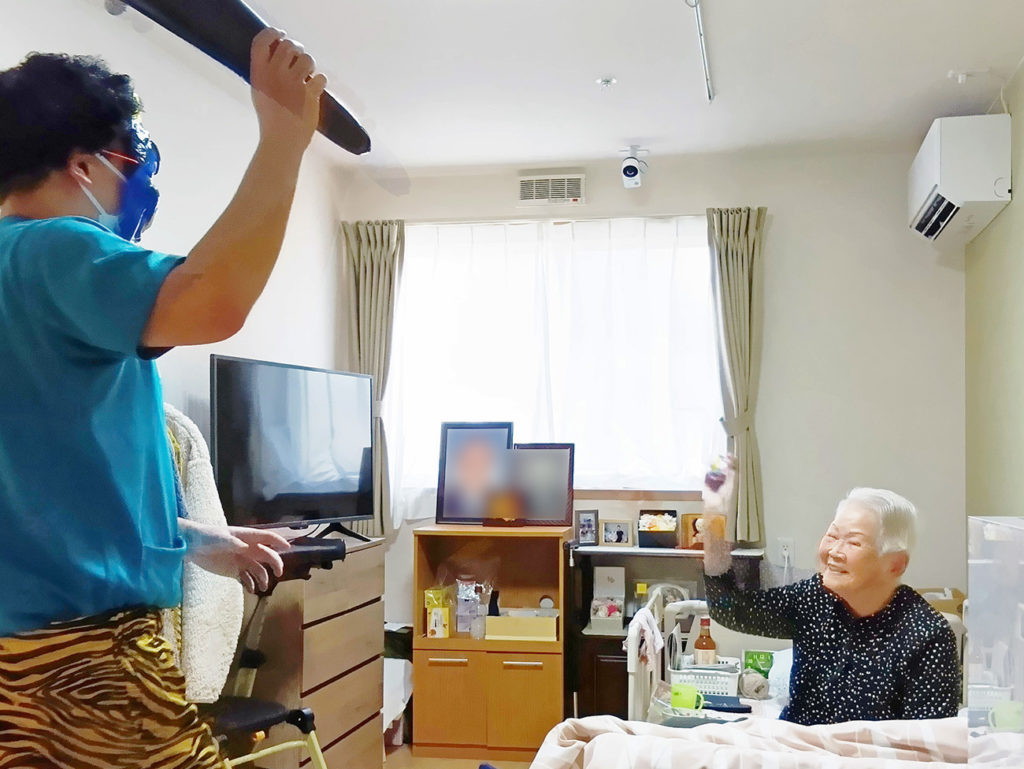 青鬼に扮したスタッフに笑顔で豆を投げる入居者さま