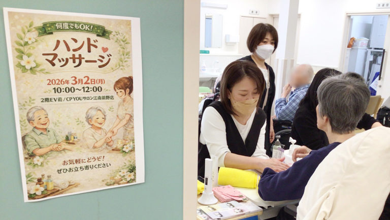 告知ポスターが貼られている奥でハンドマッサージが行われている様子