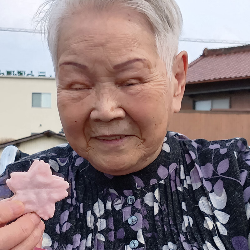 桜型のお菓子を食べる入居者