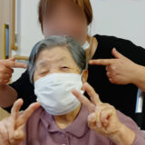 みのりあカフェを楽しんで両手ピースする入居者さまとご家族